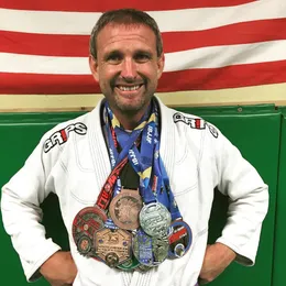 A Boran Brazilian Jiu-Jitsu competitor wearing medals won at IBJJF and open tournaments