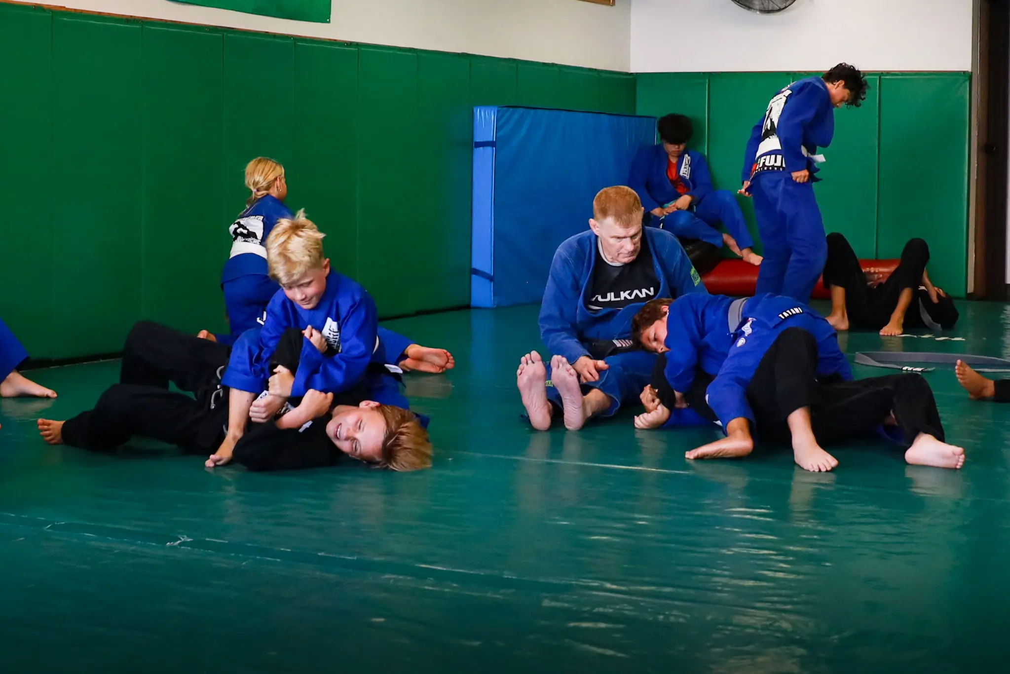 The whole class rolling in pairs across the mat at the end of a session, with Professor James Boran in the middle