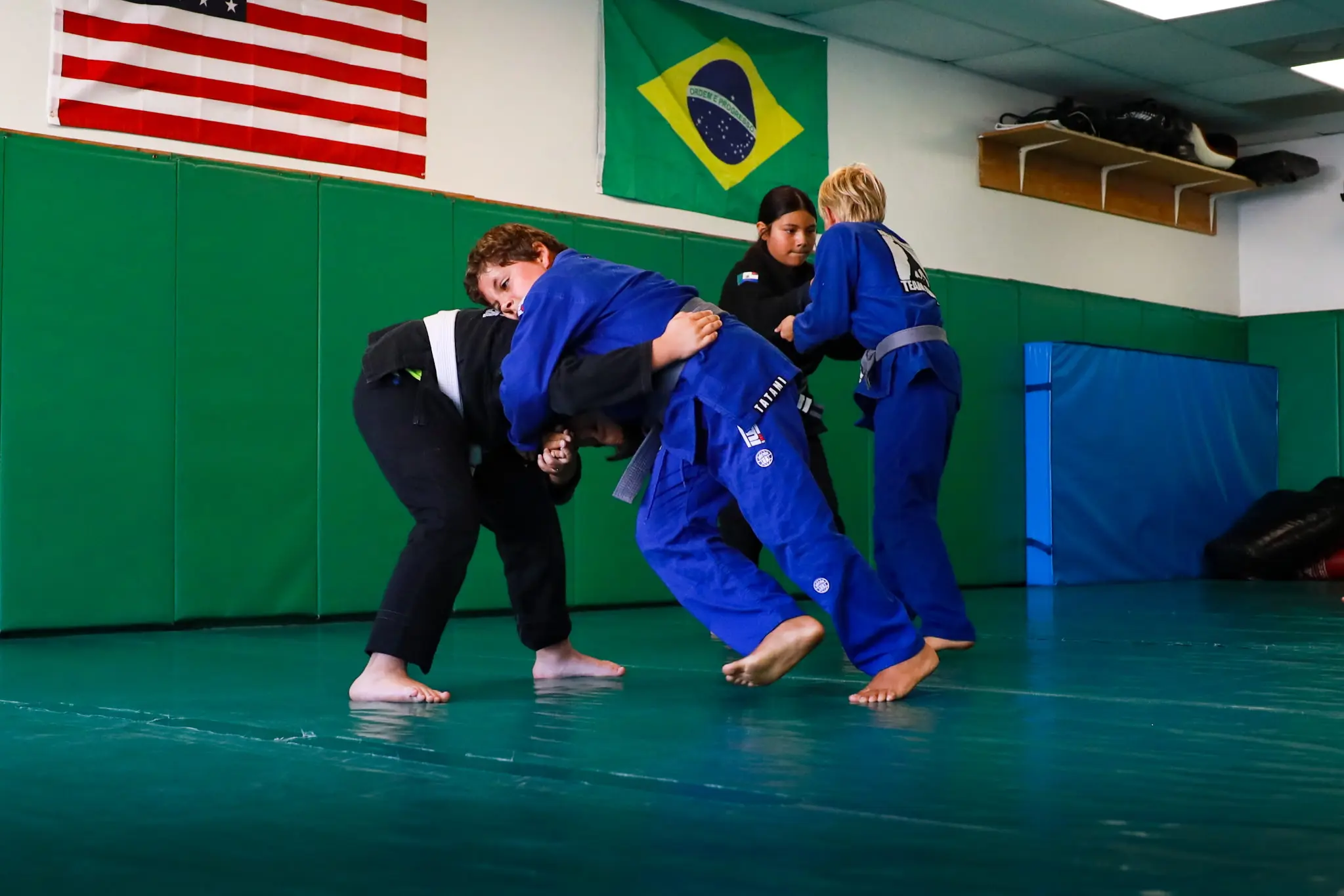 Two pairs of students fighting for grips from standing during a takedown drill